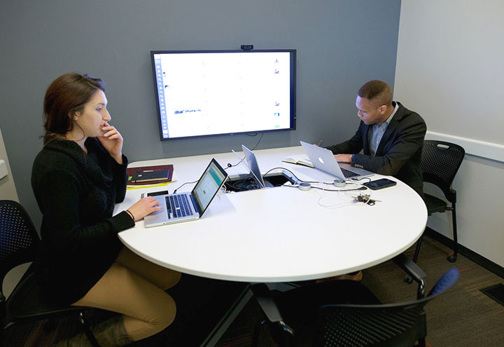 Technology Conference Room interior showing two people working on laptops