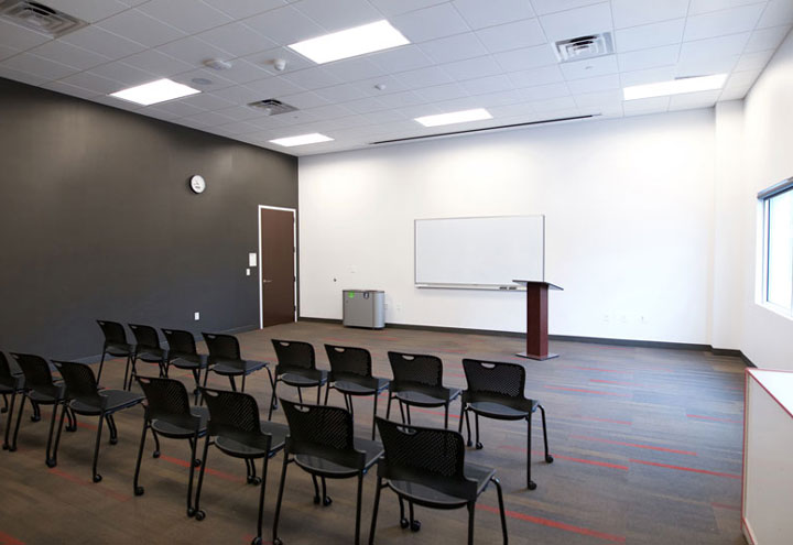 Ladd Library Community Room showing chairs arranged auditorium style with screen at front of room