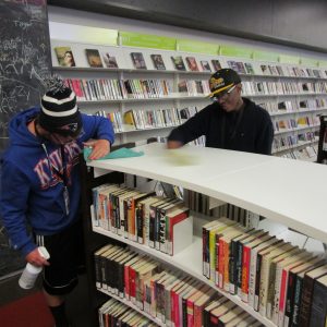Volunteers cleaning a set of library shelves