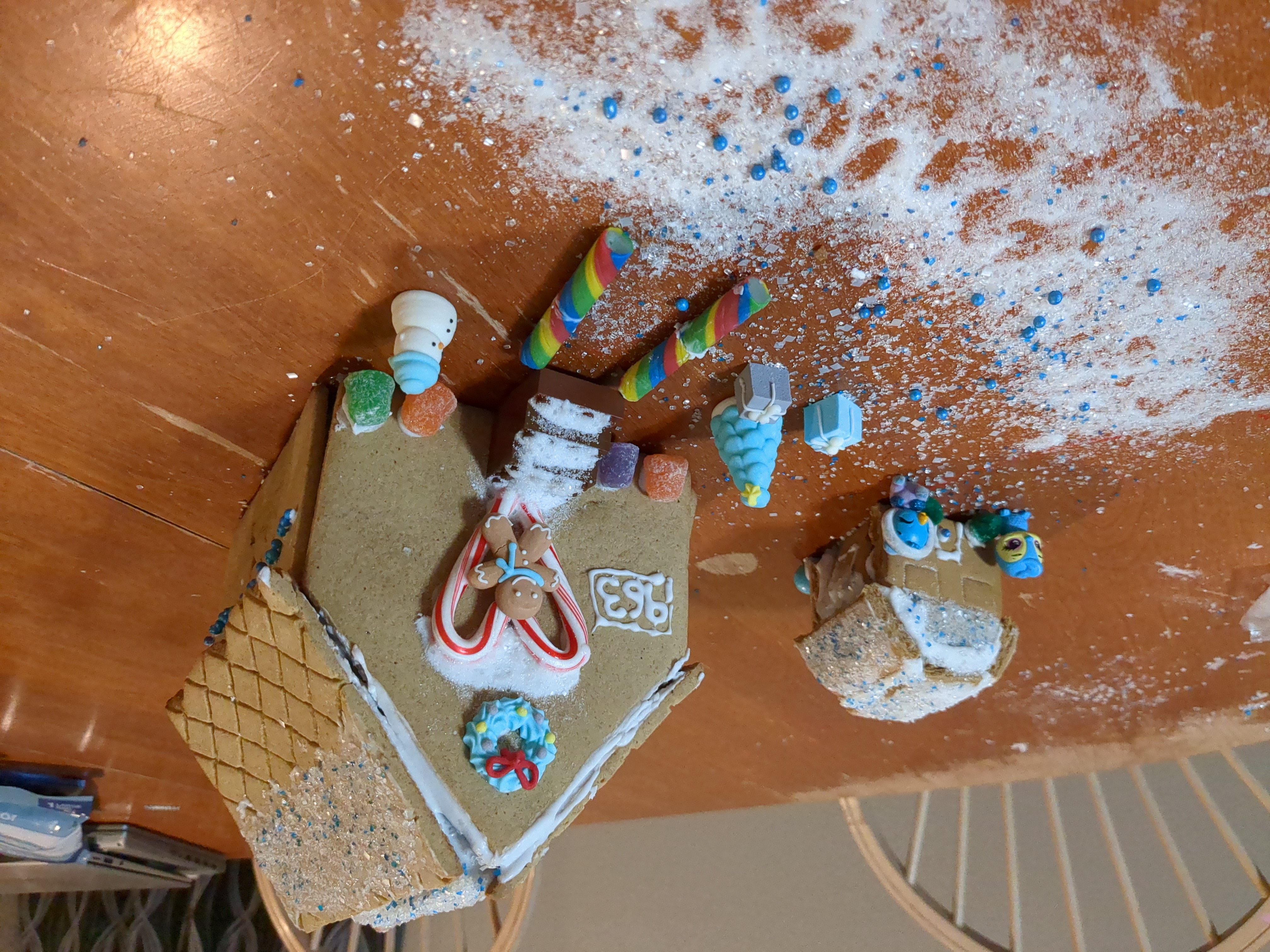 A gingerbread house has a heart shaped candycane door.