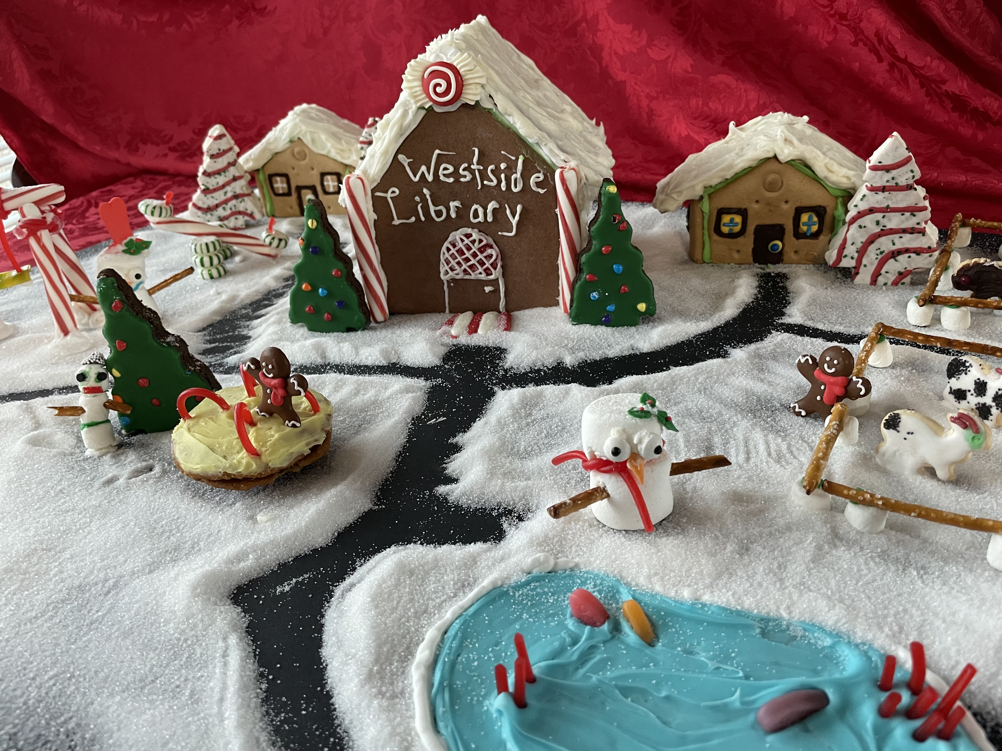 A gingerbread library says "Westside Library" and has a pond, two smaller buildings, and a zoo with marshmallow animals.
