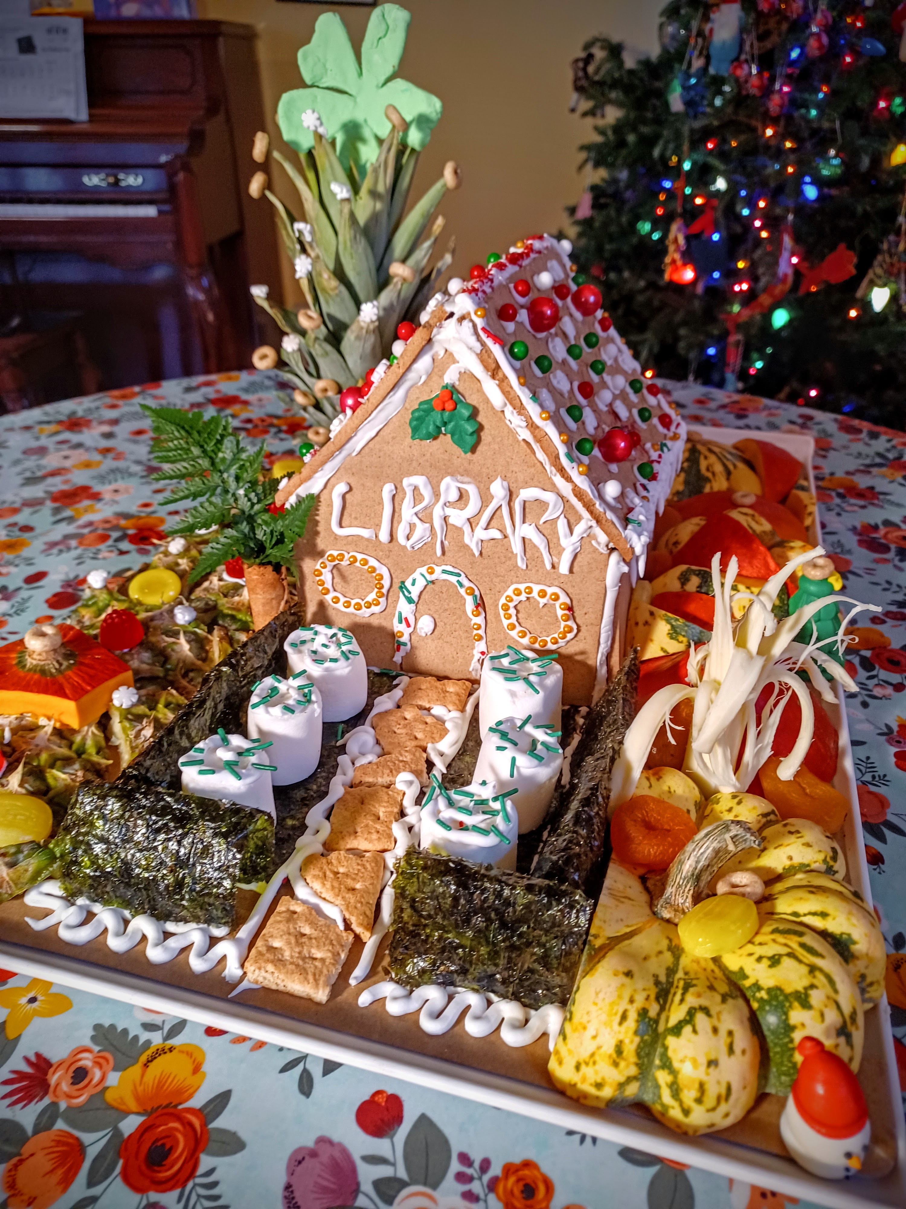 A gingerbread library has a garden made from marshmallows and vegetable scraps.