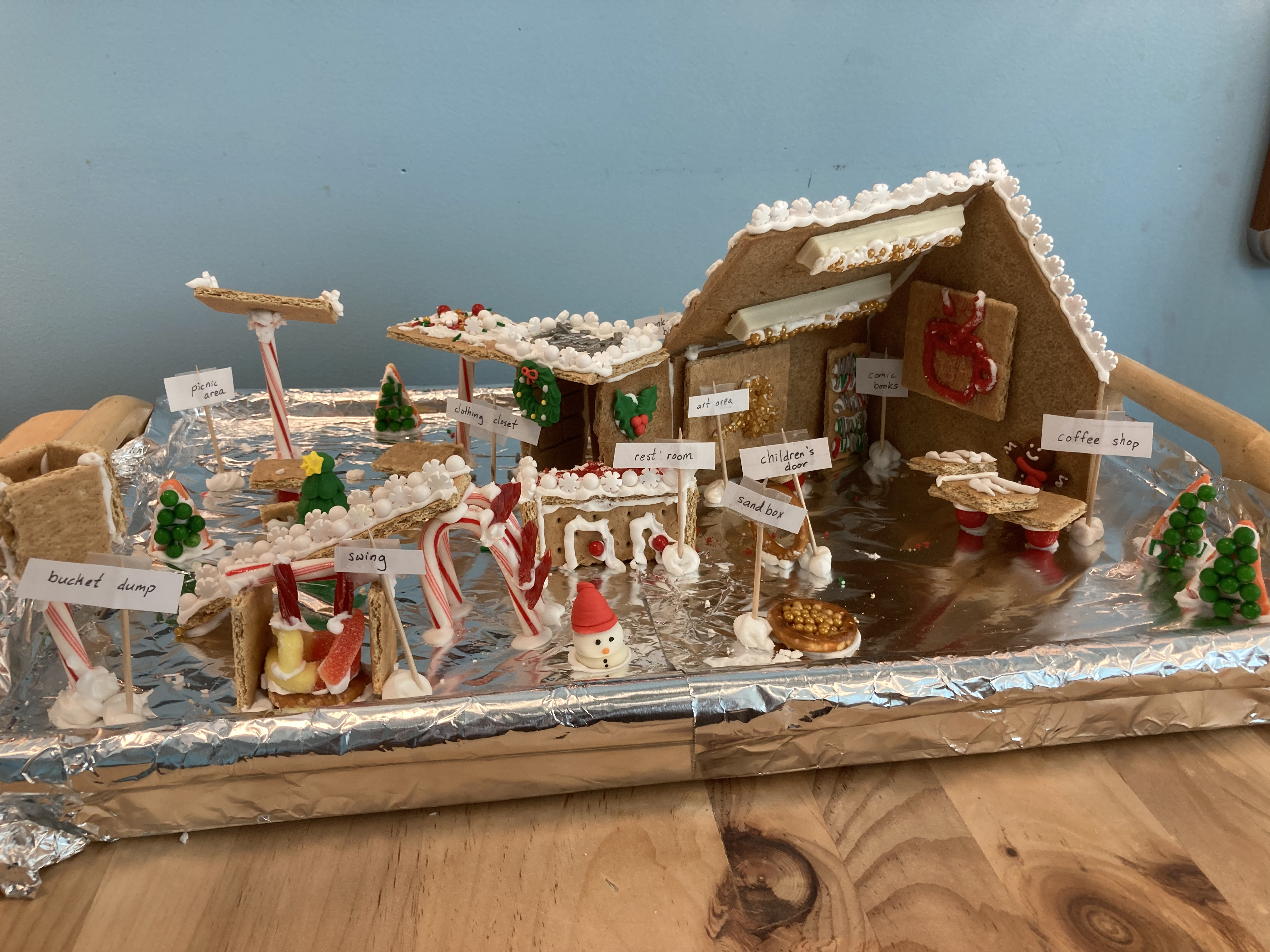 A gingerbread library has an elaborate park with many features in front.