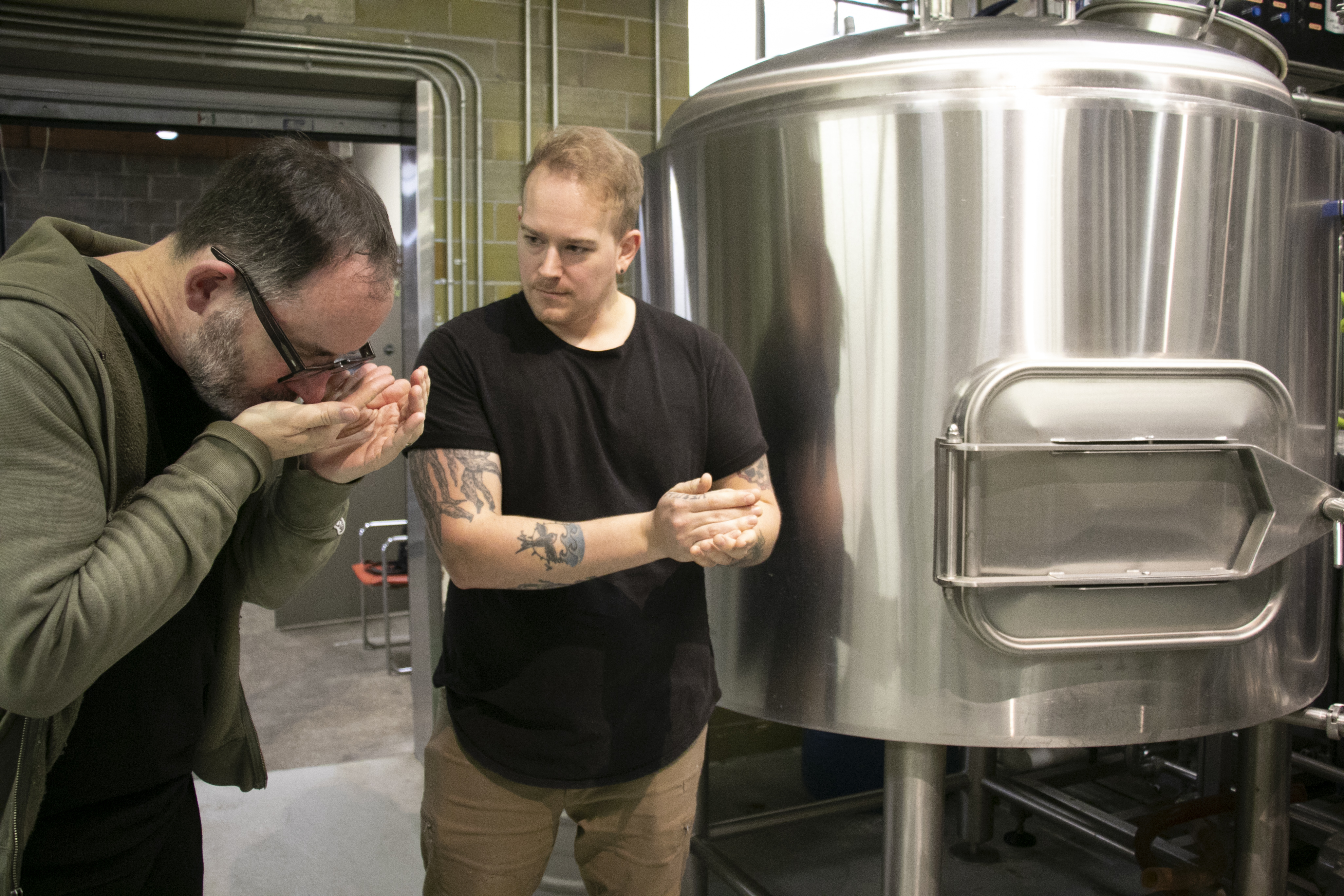 City Council member David Maier smells hops while helping brew Library Lager.