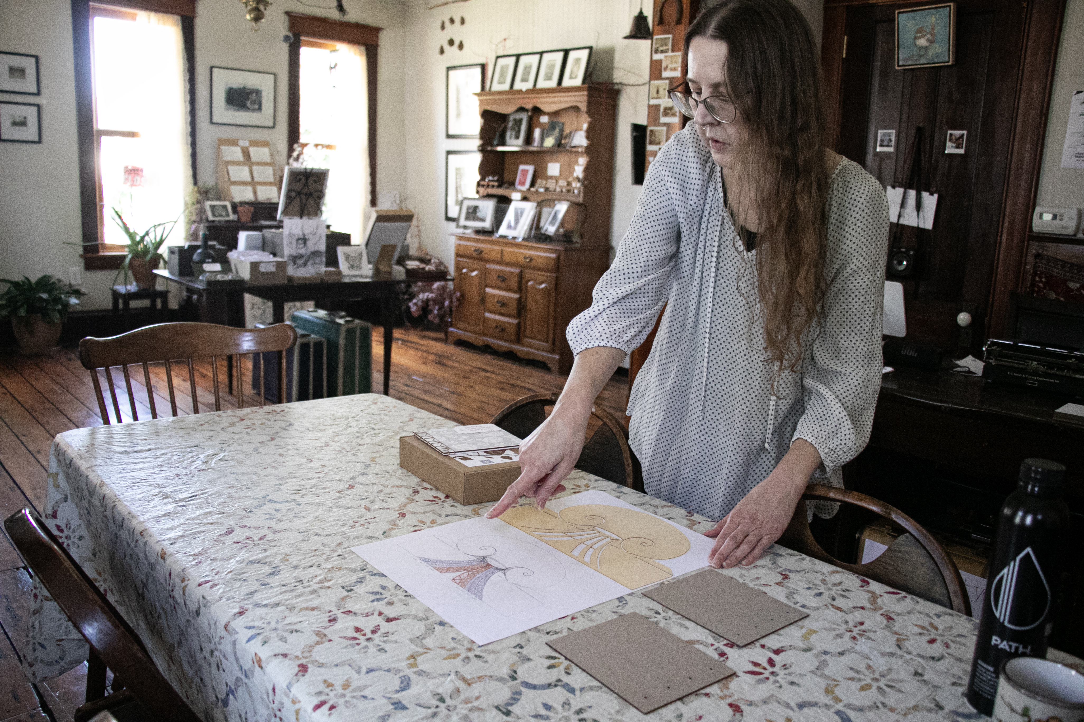 Missa Coffman points to a stencil she created in the library's Maker Spaces in her shop, Tree of Liminality.