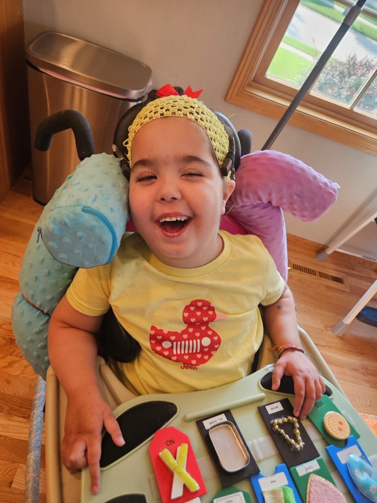 A girl in a wheelchair smiles.