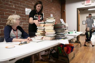 volunteers working a table at the friends of the library book sale