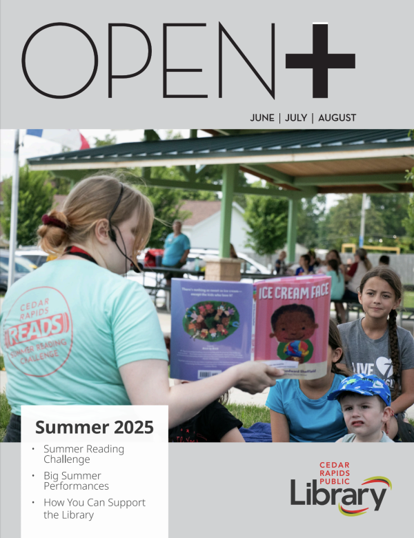 The cover of OPEN+ magazine has a photo of a woman reading to children in a park.