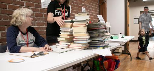 volunteers working a table at the friends of the library book sale