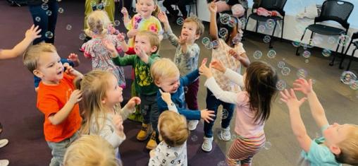 Children play with bubbles in the library.