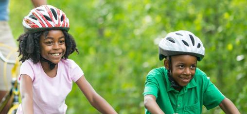 two children riding bicycles on a trail with logos of both the Cedar Rapids Public Library and Linn County Public Health