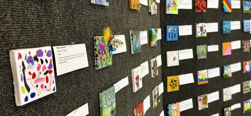 Walls are covered with Tiny Art canvases.