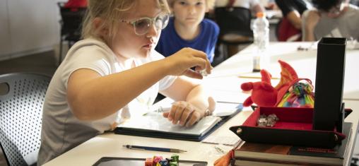 A girl rolls a dice while playing Dungeons and Dragons.