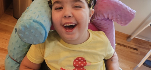 A girl in a wheelchair smiles.