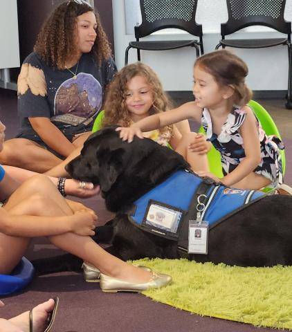 Children petting Hopkins the Therapy Dog.