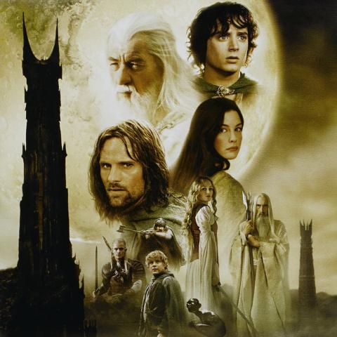 Characters from "The Two Towers" stare into the distance in front of the tower of Sauron.