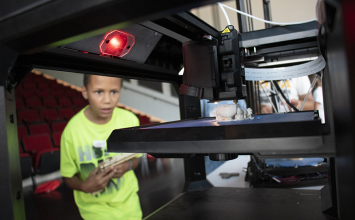Young boy watching 3D printer