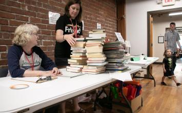 volunteers working a table at the friends of the library book sale 
