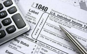 tax forms with a calculator on top
